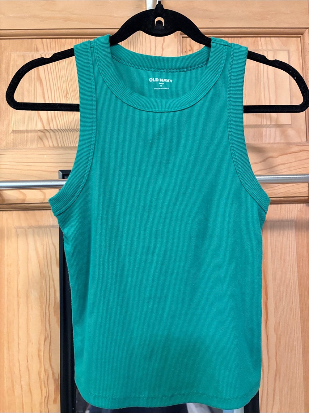 This image shows a green, ribbed crew neck tank top with a slim fit